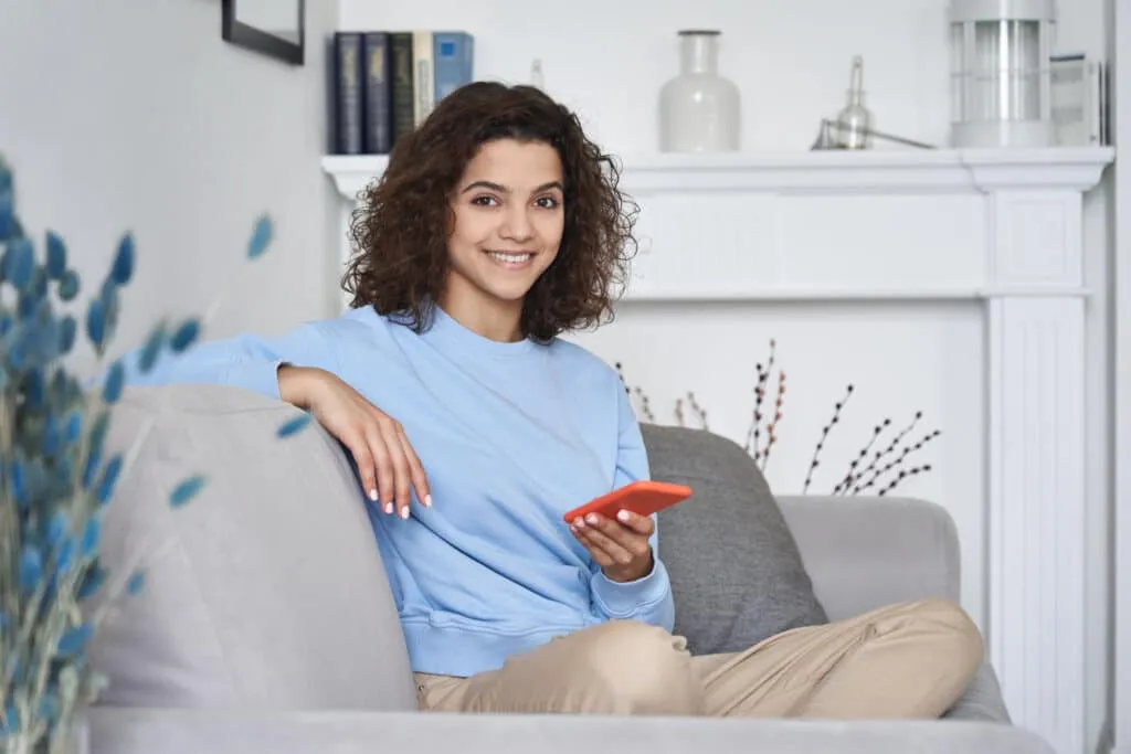 Woman sitting on the couch holding a phone